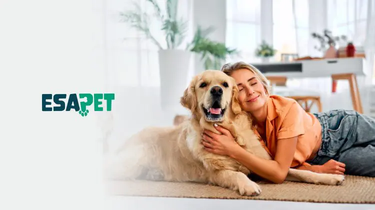 Apartment Pet Policy and What to Know Before Renting for Pet Owners 1 A smiling woman lying on the floor hugging a golden retriever dog in a bright apartment, representing apartment pet policies for ESA owners